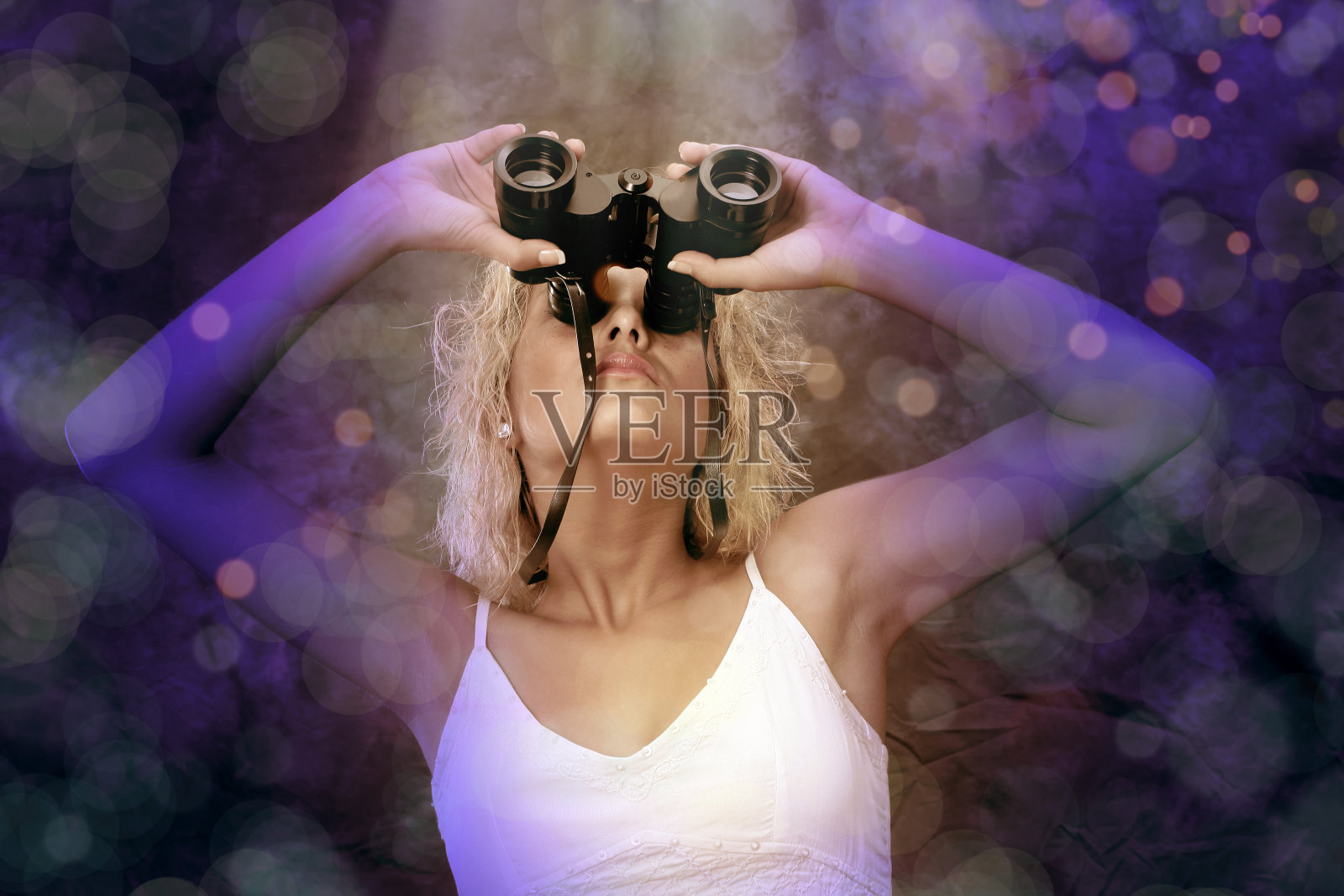 近距离观察年轻女子透过双筒望远镜照片摄影图片