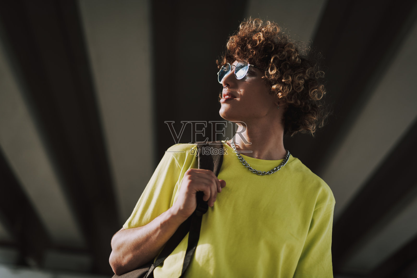 微笑卷曲的年轻人背着黑色的背包照片摄影图片