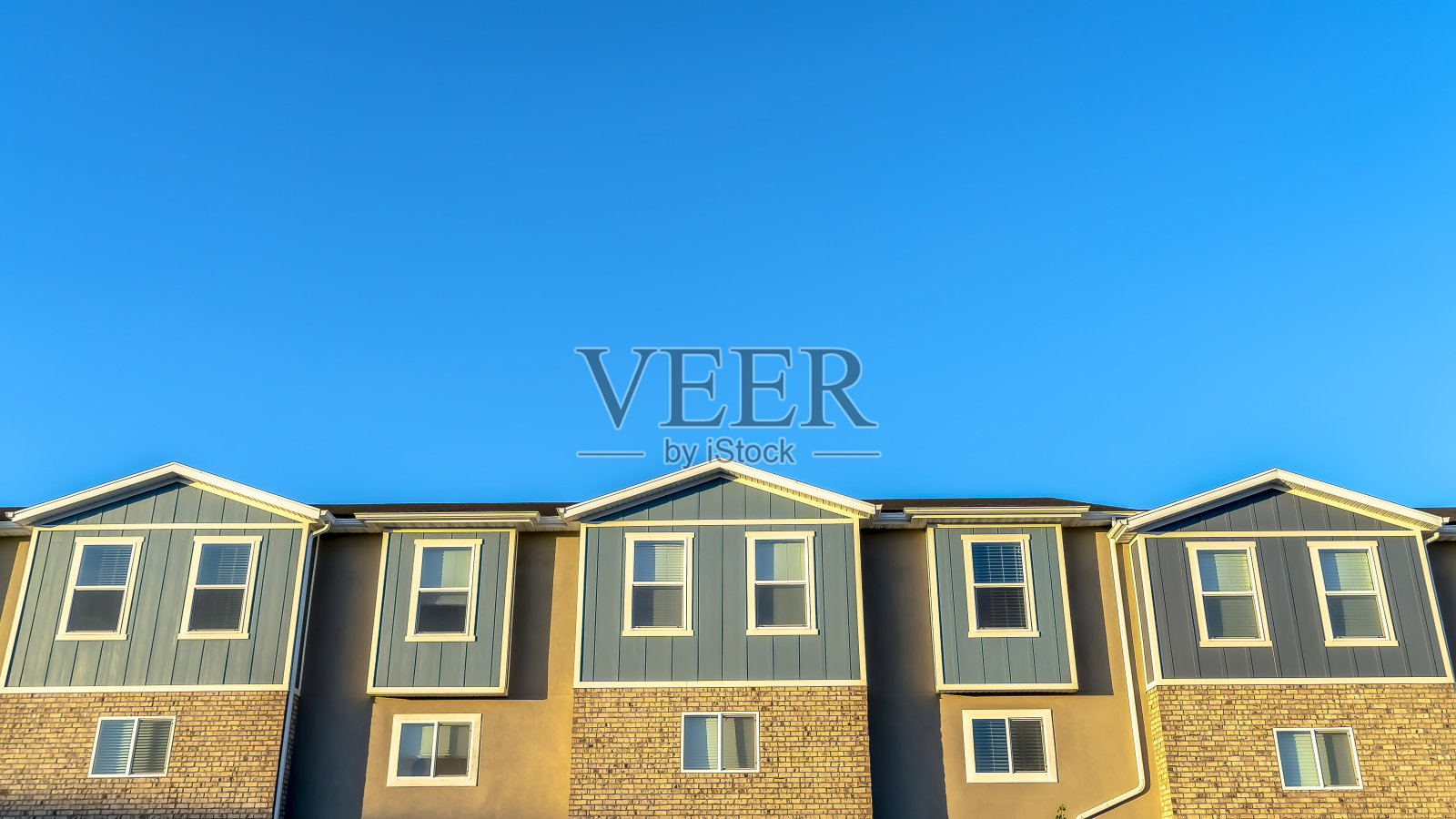 全景晴天的联排别墅外部对抗充满活力的蓝天照片摄影图片