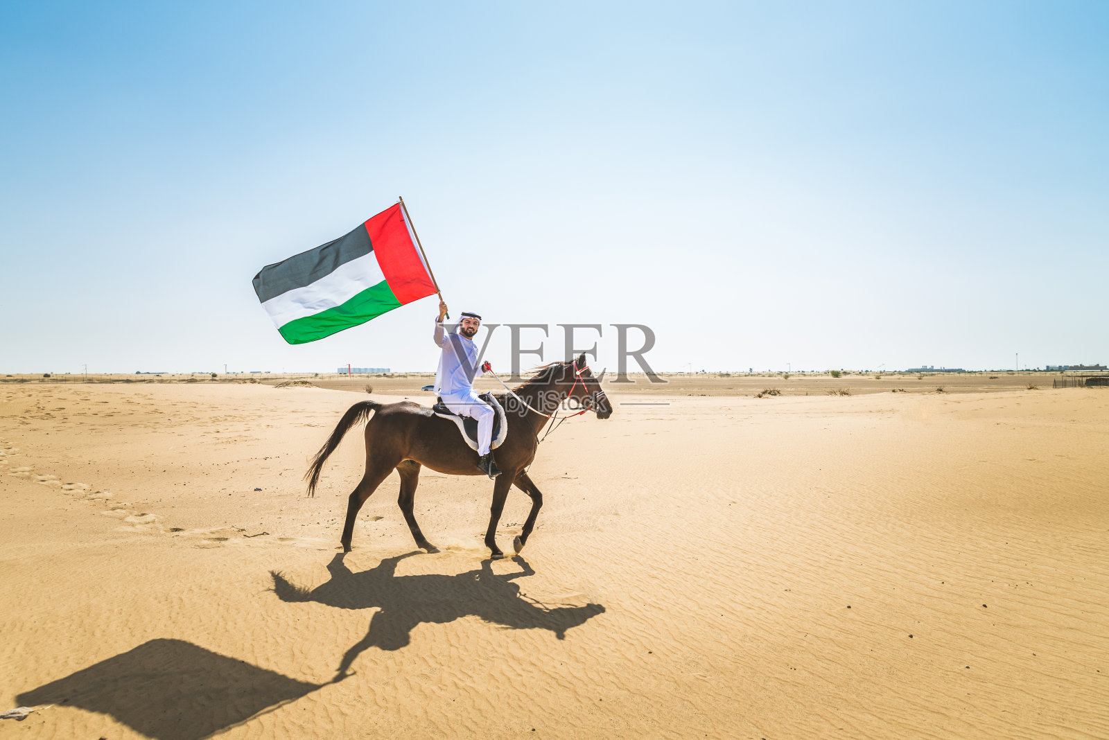 沙漠里骑着马的阿拉伯人照片摄影图片