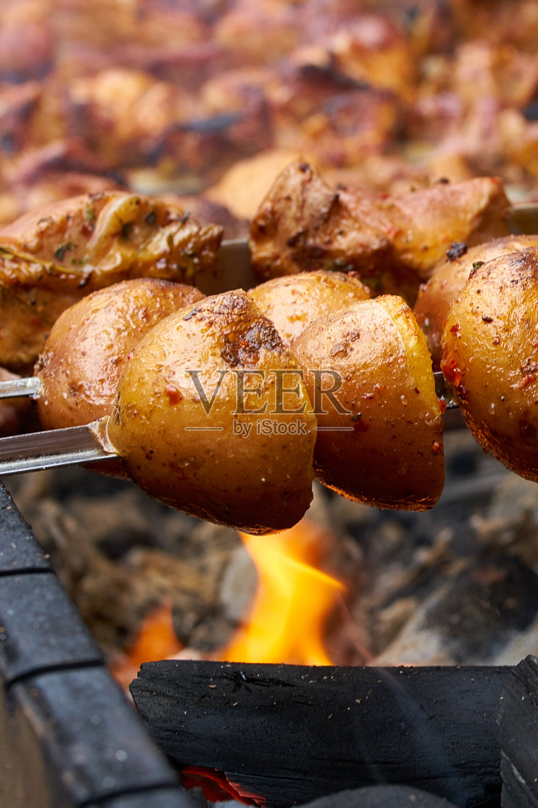 烤土豆串,在火上烤。用火煮的美味食物。近距离照片摄影图片