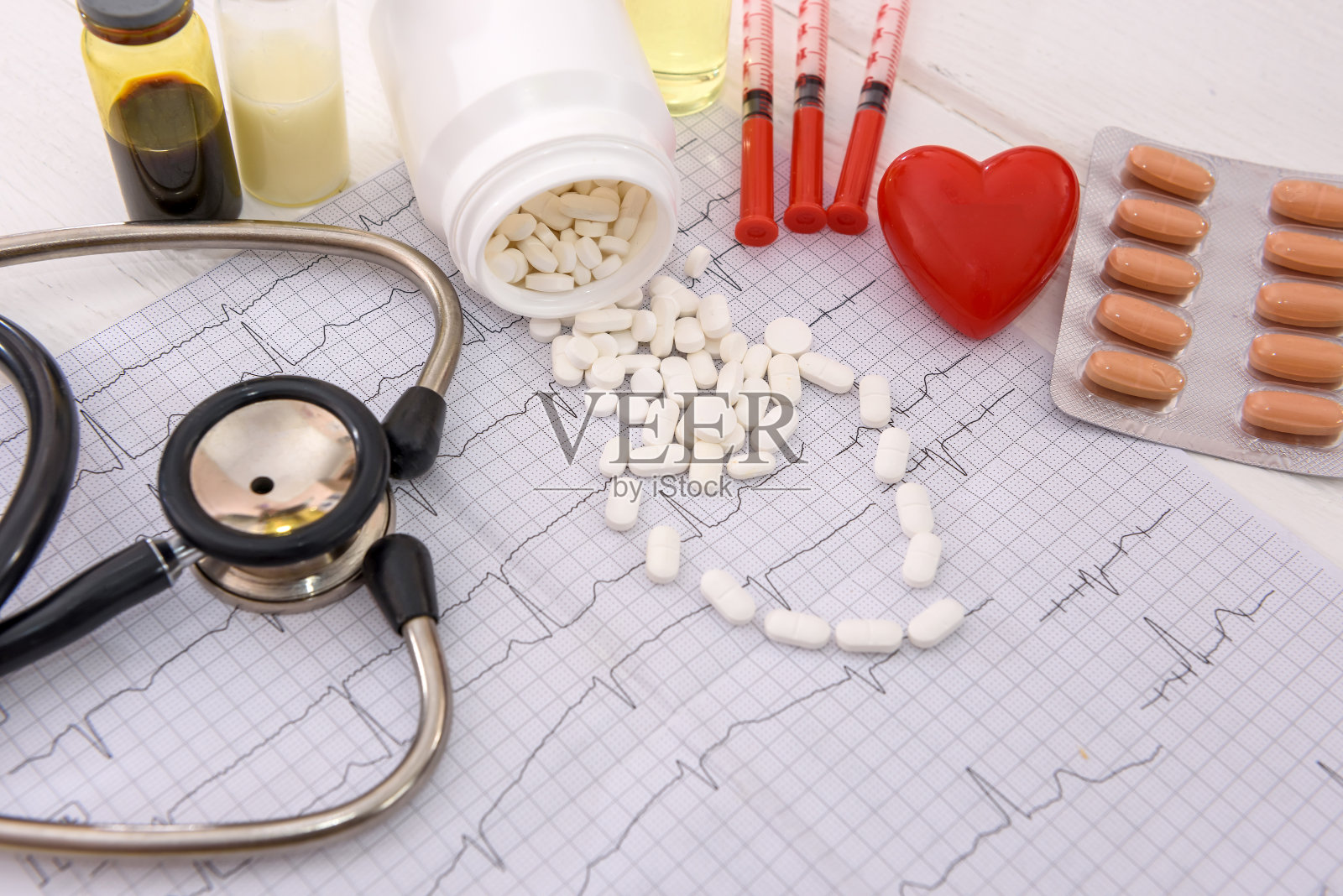 心电图上的白色药丸,还有药物和注射器照片摄影图片