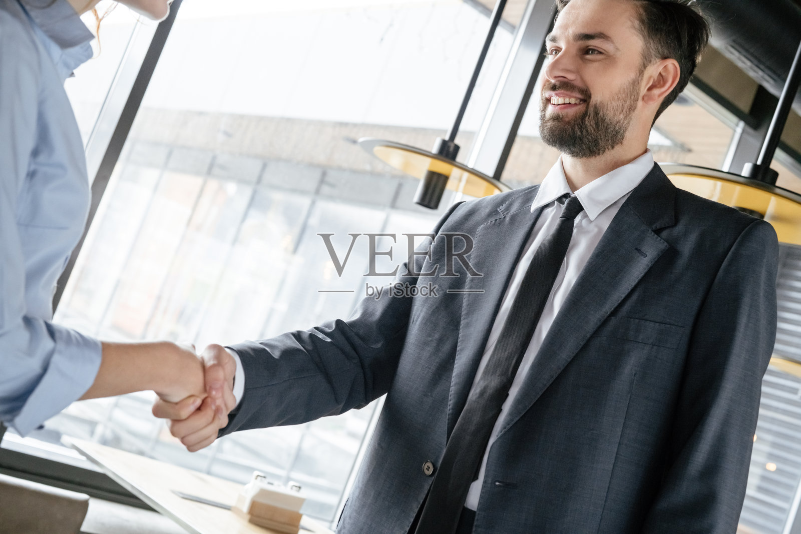 商务人士在餐厅吃商务午餐时站着握手照片摄影图片