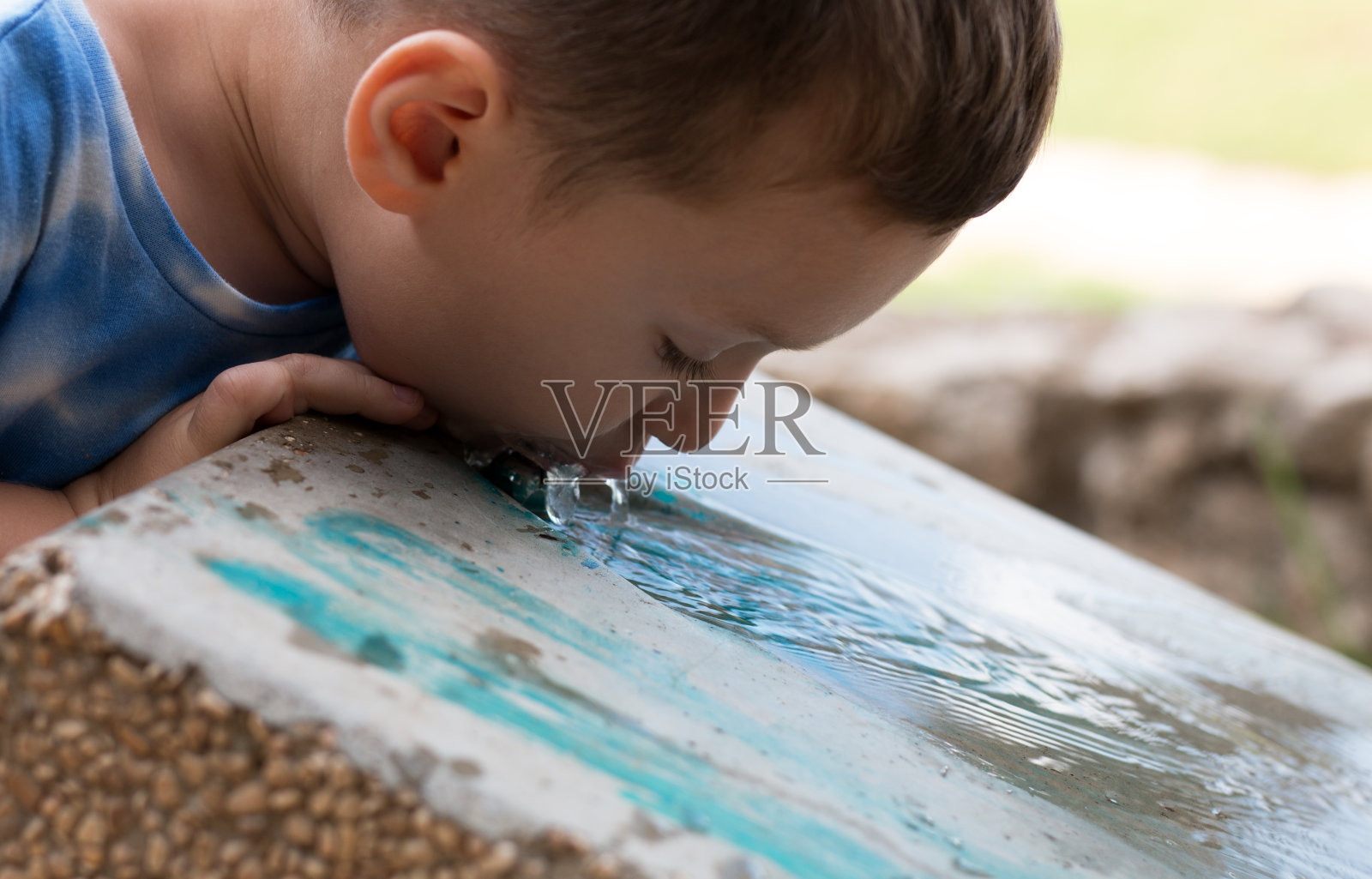 孩子在公园里从冷藏箱喝冷水照片摄影图片