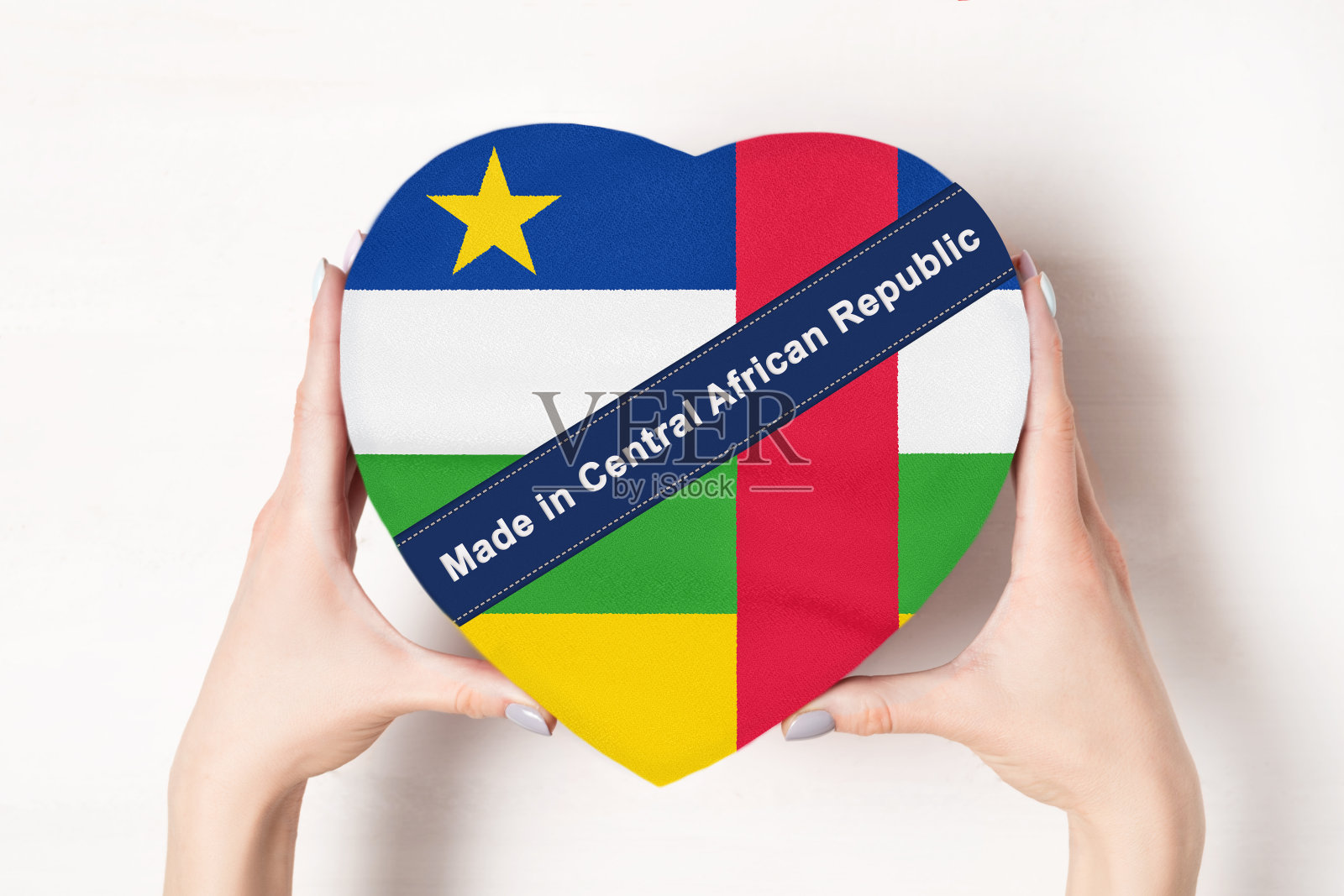 在中非共和国制作的铭文中非共和国国旗。女人的手拿着一个心形的盒子。白色背景。照片摄影图片