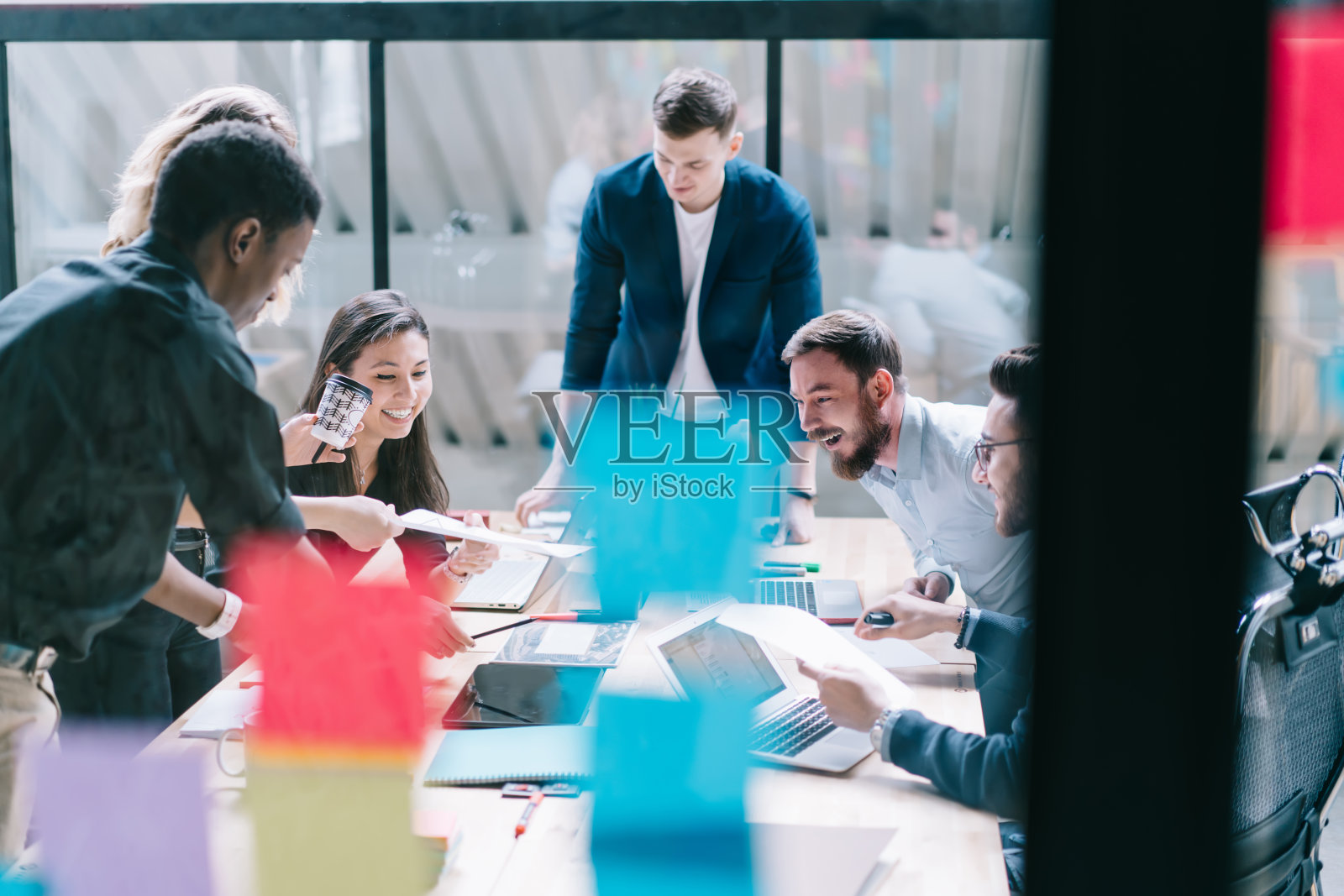 多元文化团队的奇迹创造性的男性和女性设计师在正式的穿着大笑在新项目的合作有头脑风暴会议后的玻璃墙在现代办公室照片摄影图片