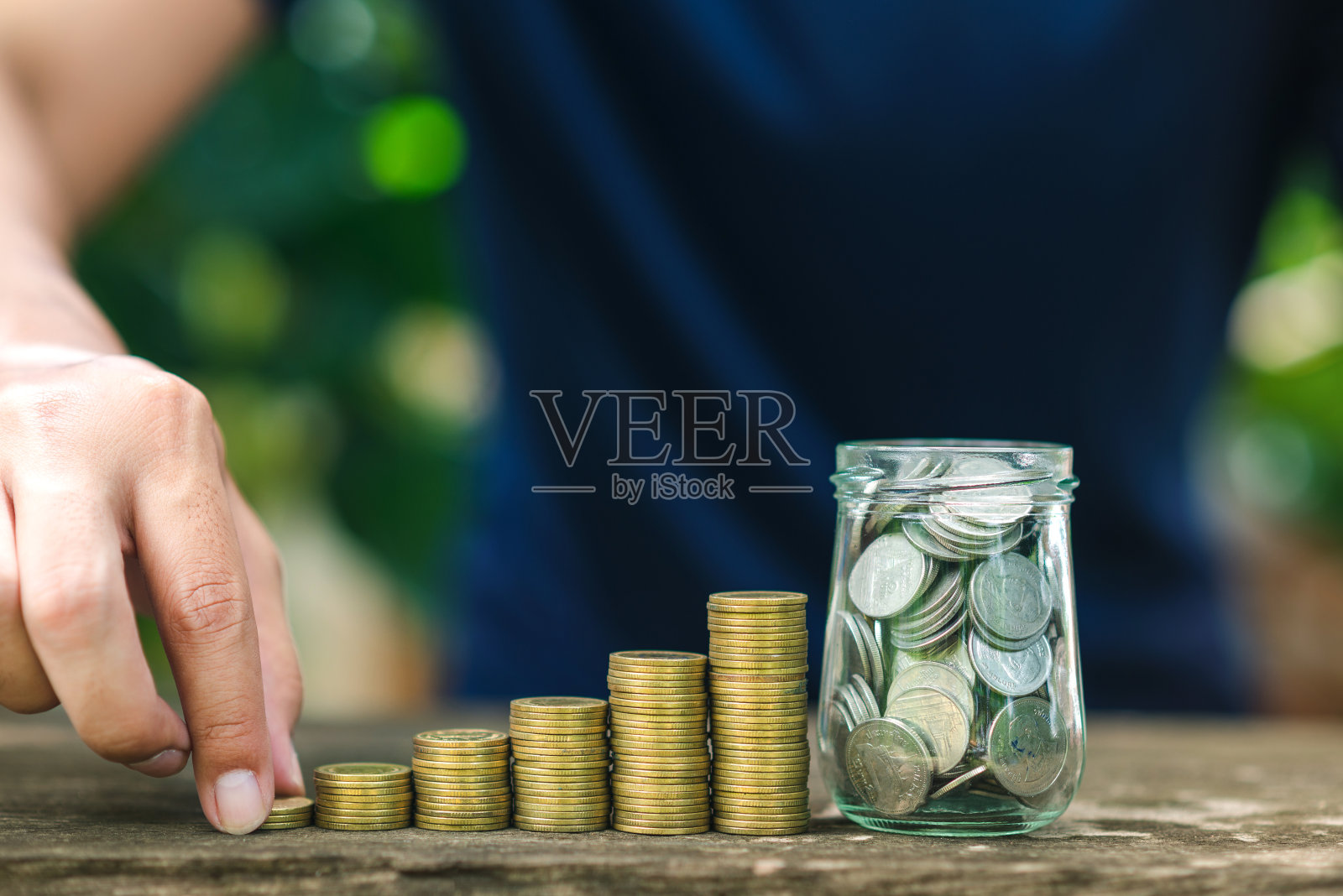 用手握硬币的省钱理念在硬币堆上不断增长的业务照片摄影图片