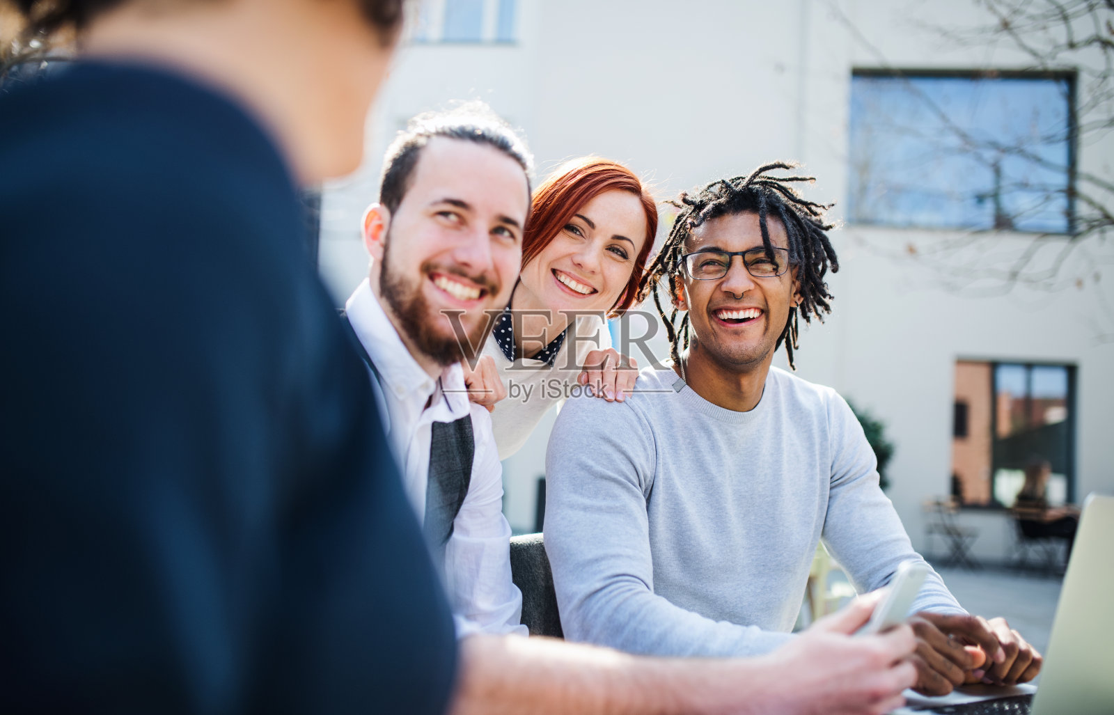 一群年轻的商人在院子里使用笔记本电脑,创业的概念。照片摄影图片
