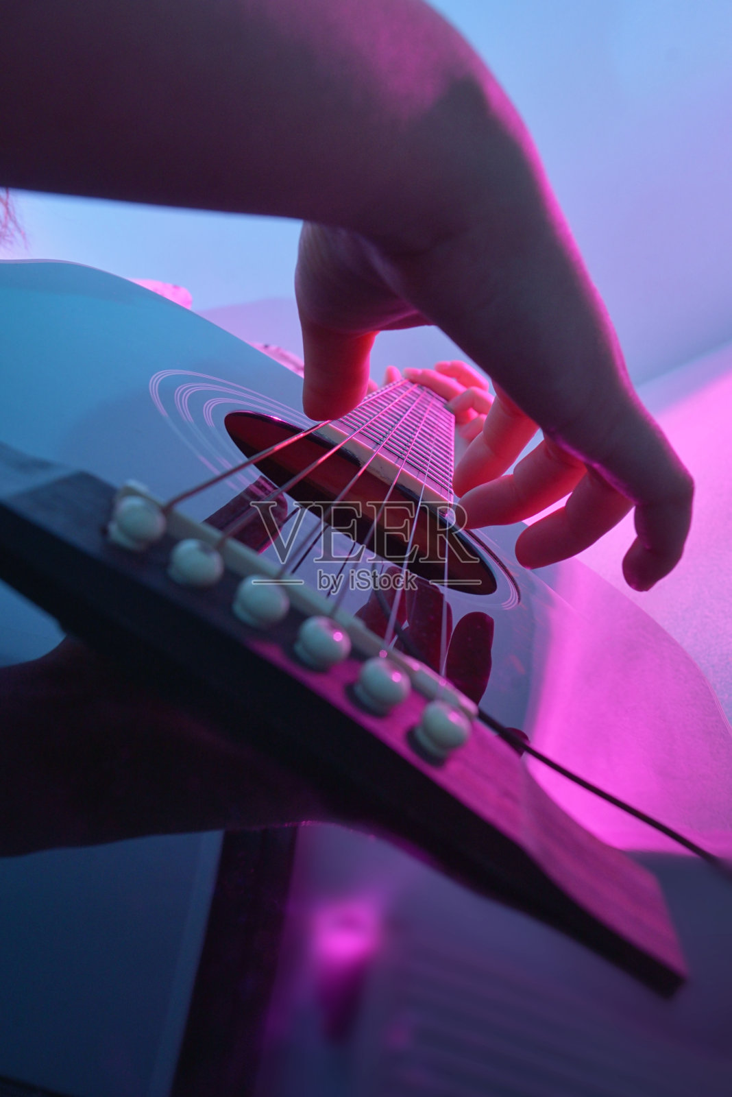 由一个女孩弹奏的原声吉他和五颜六色的灯光照片摄影图片