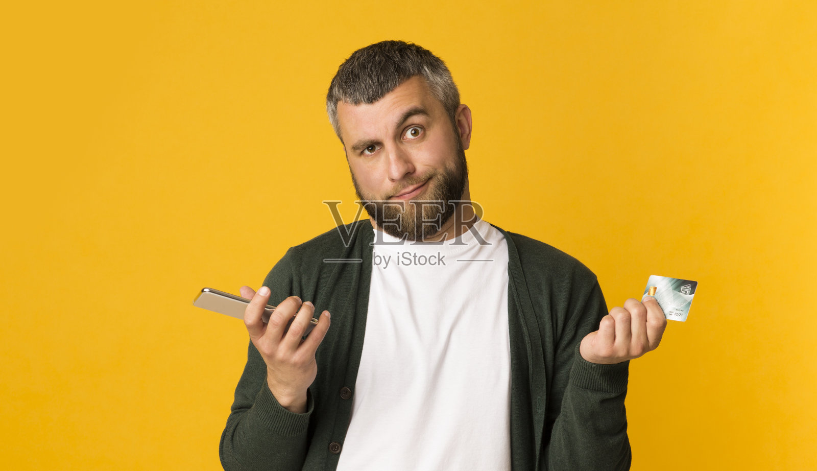 拿着手机和信用卡的困惑男子照片摄影图片