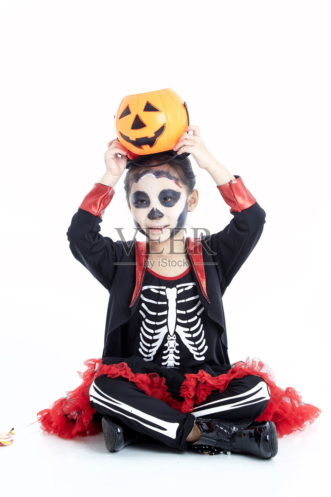 快乐的亚洲小女孩在万圣节骷髅服装孤立的白色背景照片摄影图片