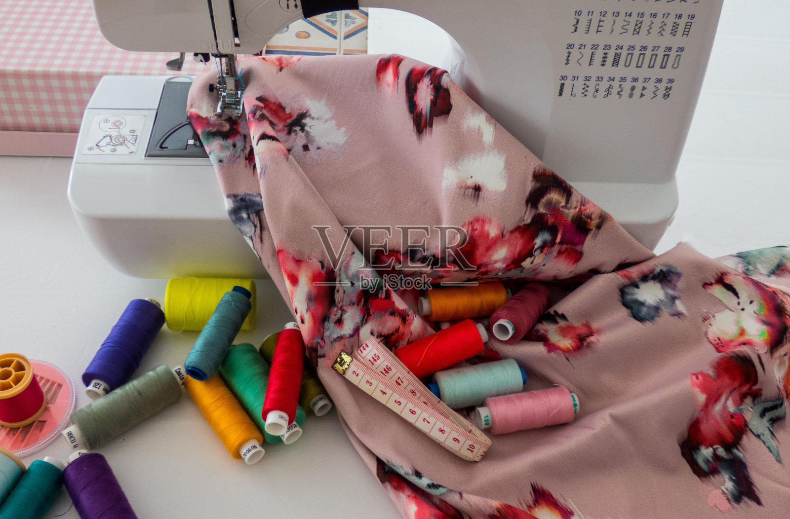 缝纫机、布料、棉线及缝纫用的彩线。前视图。照片摄影图片