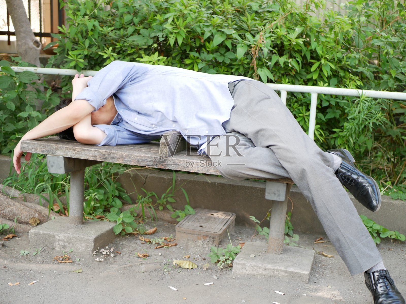 年轻男人生病躺在长椅上照片摄影图片