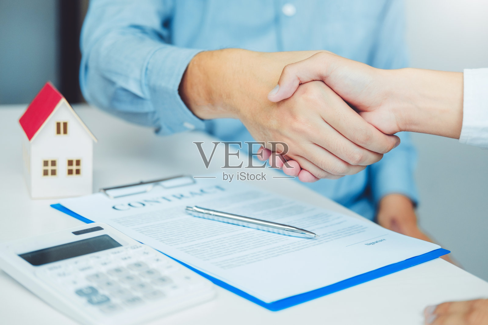 销售代理与客户握手并签订协议合同,保险到家概念照片摄影图片