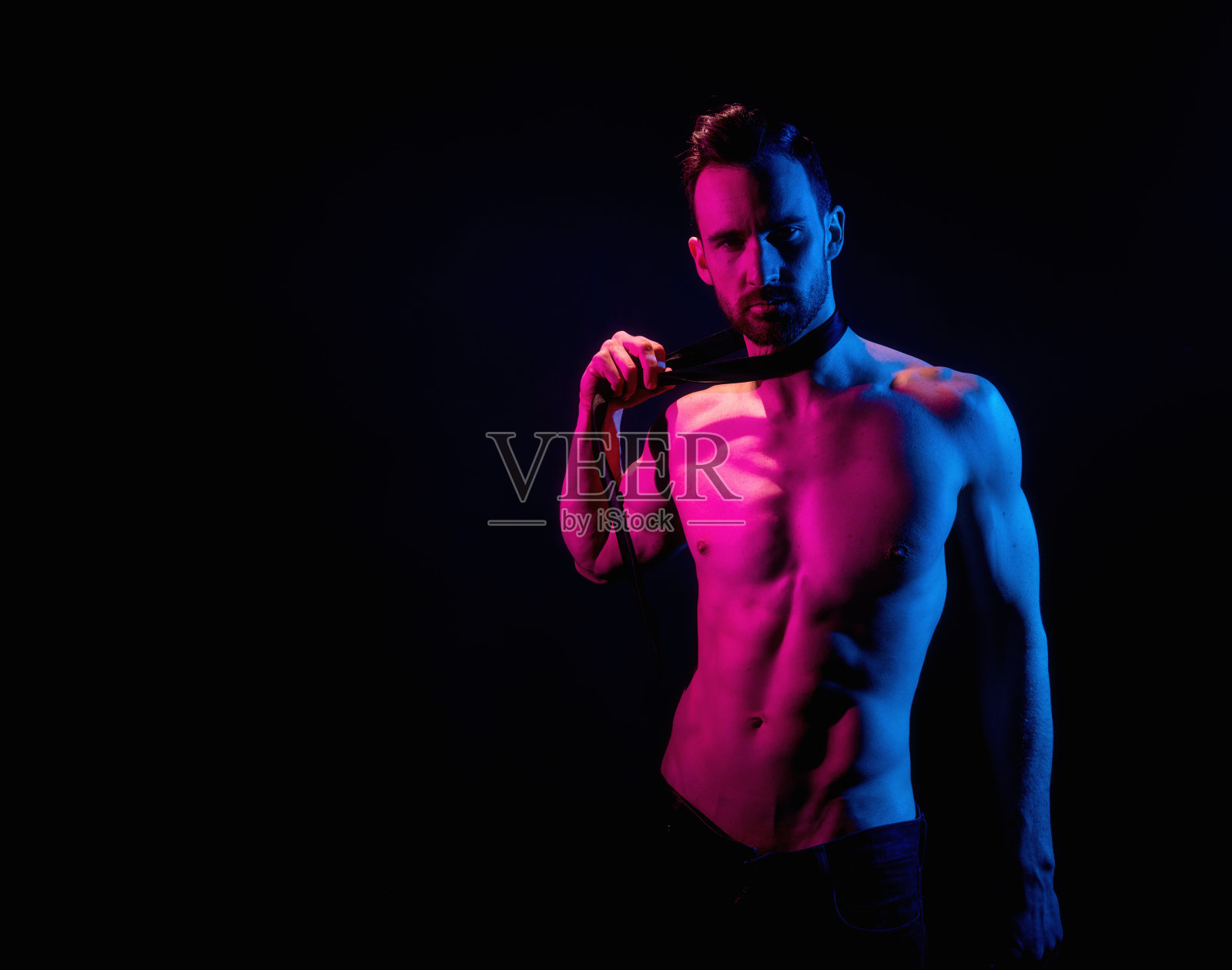 英俊的男子在黑色背景与红色和蓝色照明照片摄影图片