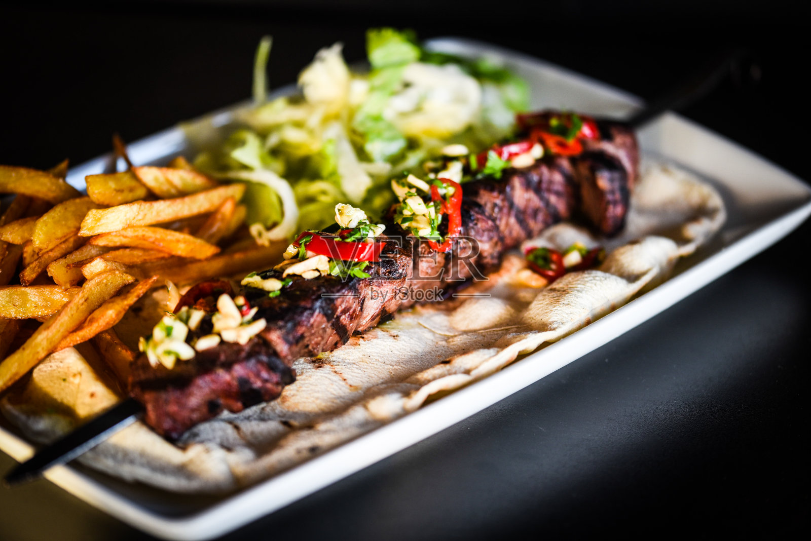 牛肉串配薯条和什锦沙拉照片摄影图片