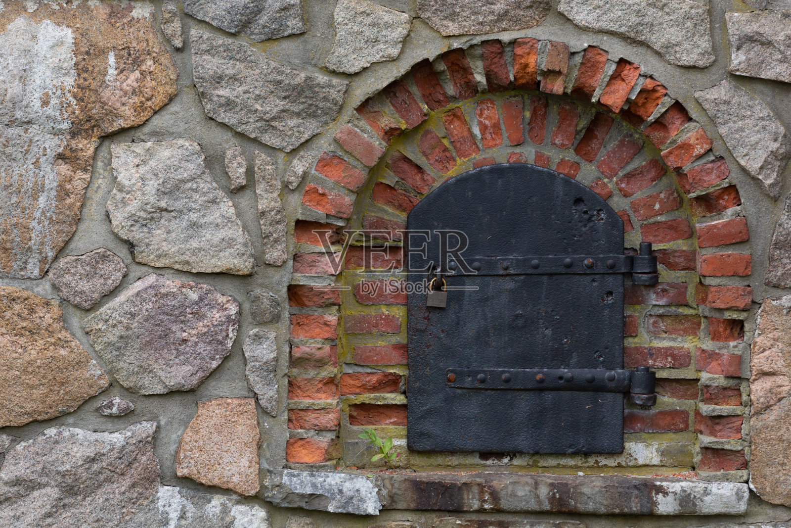 堡垒石墙上的金属古门照片摄影图片