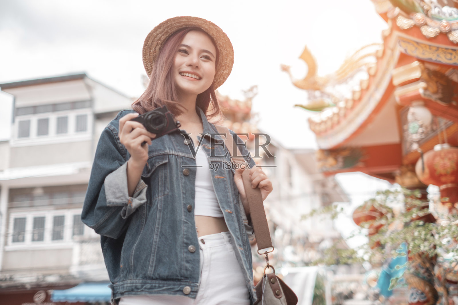 微笑的女人旅行者在清迈寺庙的地标泰国清迈拿着相机背包度假,放松的概念,旅游的概念照片摄影图片