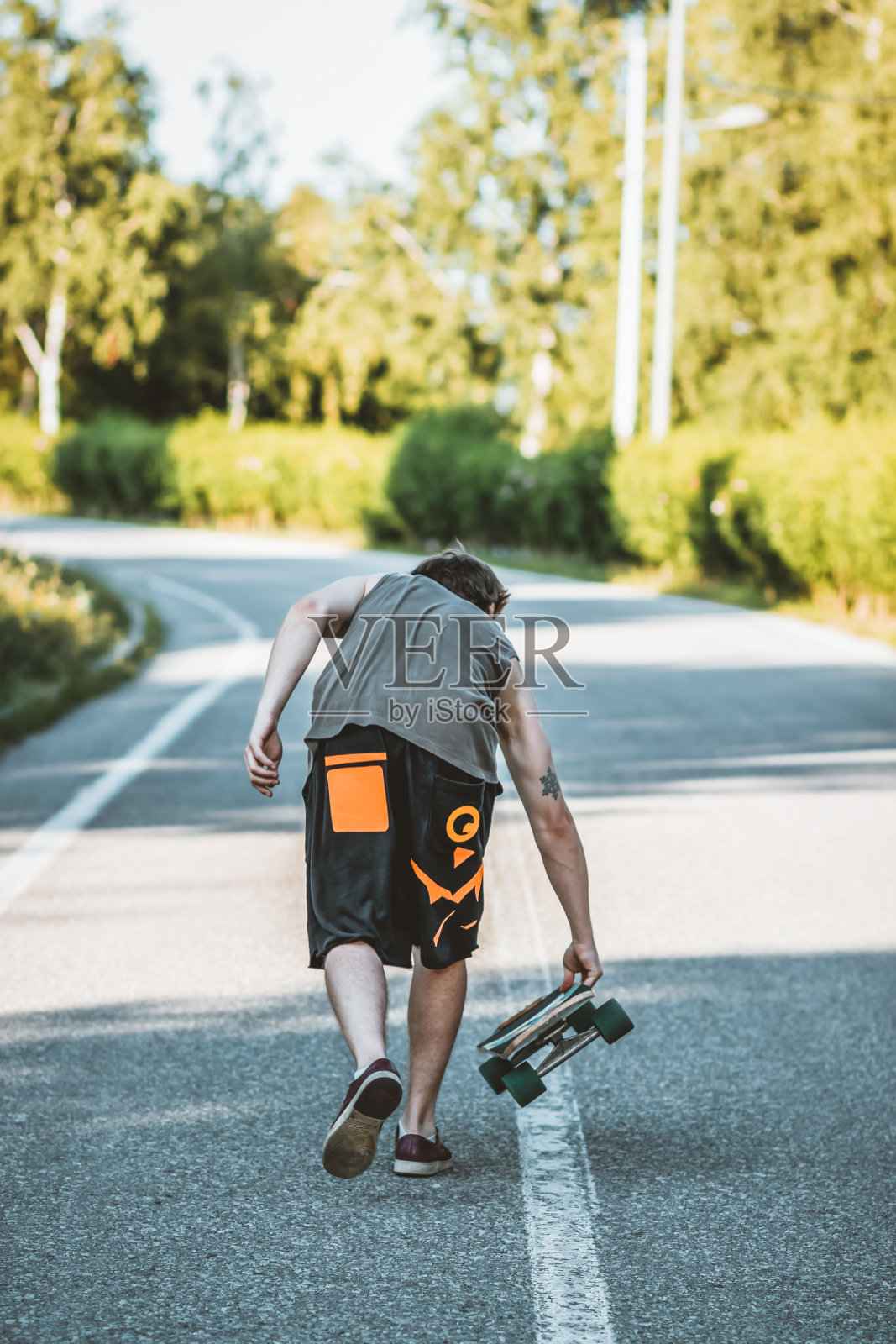 带着滑板的年轻人照片摄影图片