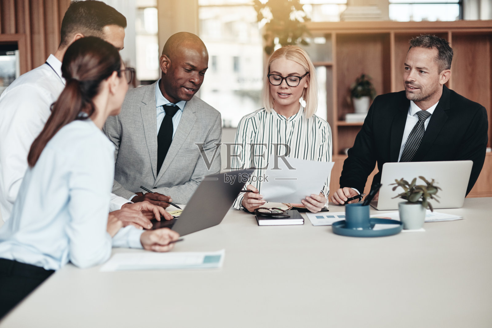 不同的商务人士在一张办公桌前一起工作照片摄影图片