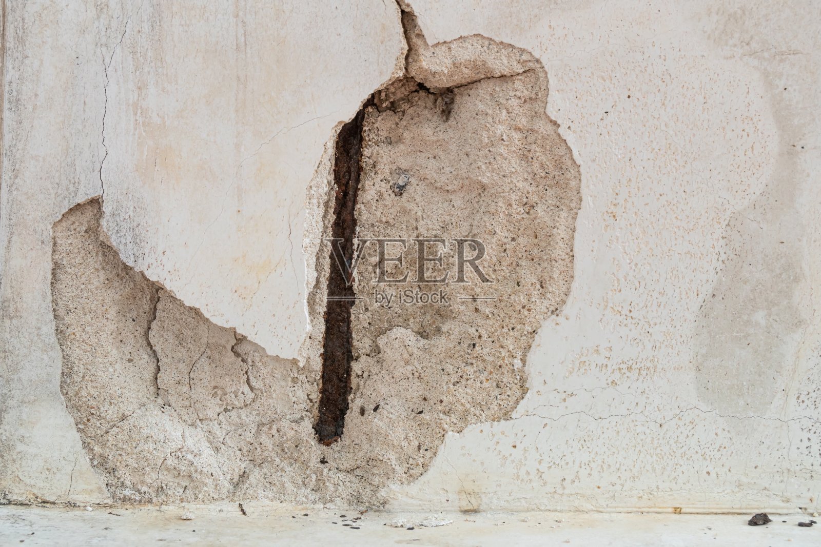 混凝土墙里面有生锈的钢线。照片摄影图片