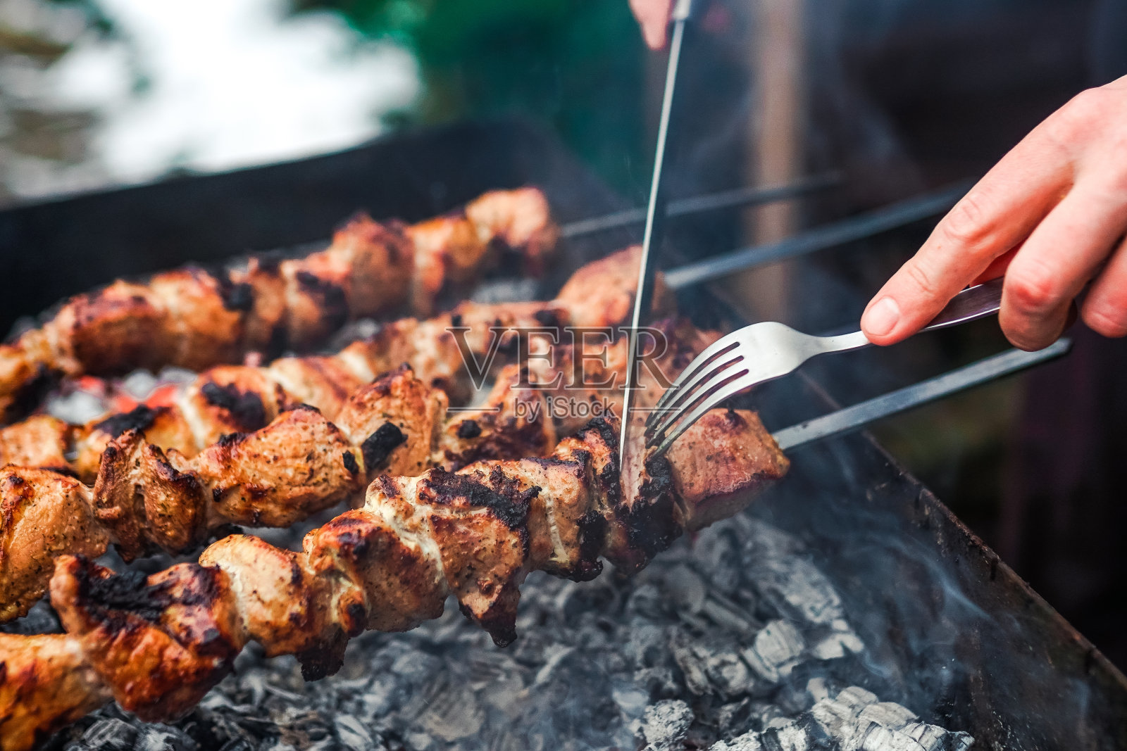 用金属串烤的烤肉串。烤肉烧烤时烤的肉传统的东方菜肴,羊肉串。炭火烧烤,野餐,街头小吃照片摄影图片