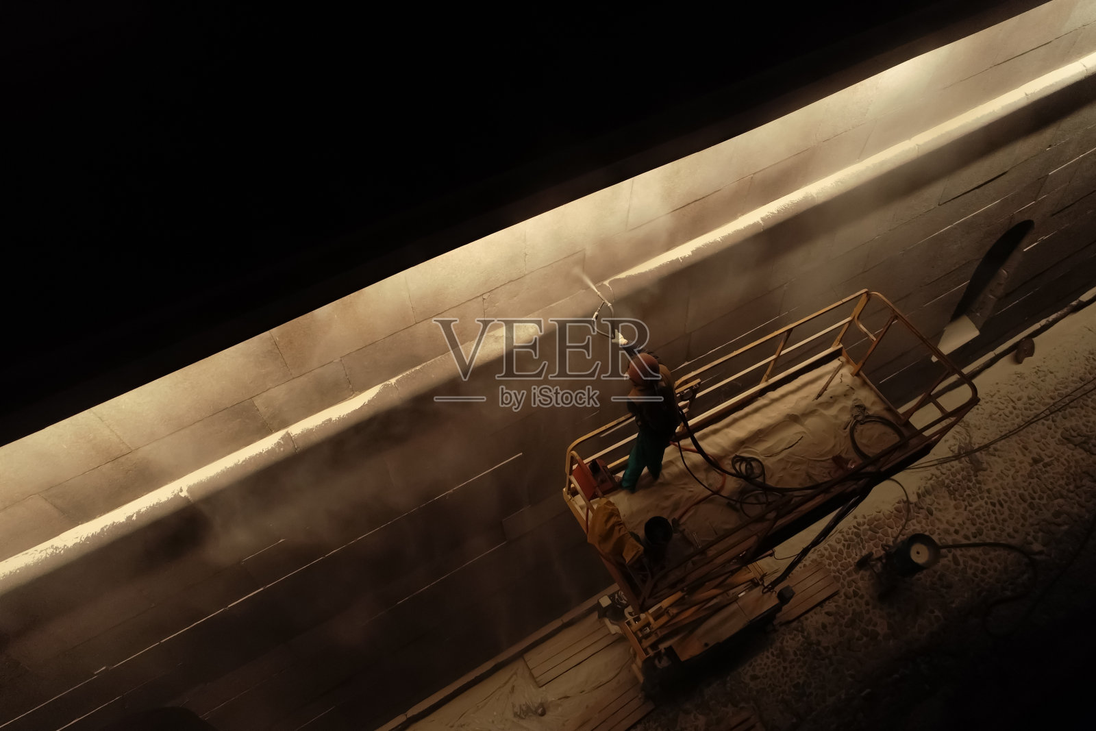 工人用喷枪在墙上喷漆照片摄影图片