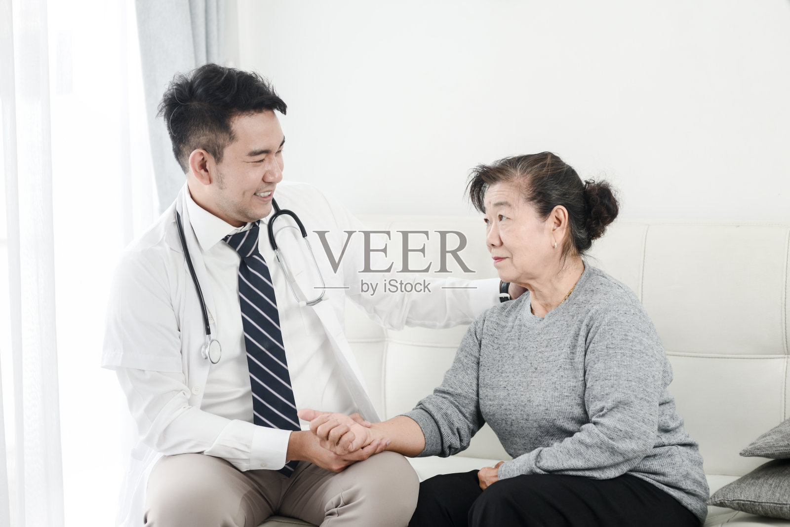 亚洲医生检查他的病人女性在办公室。照片摄影图片