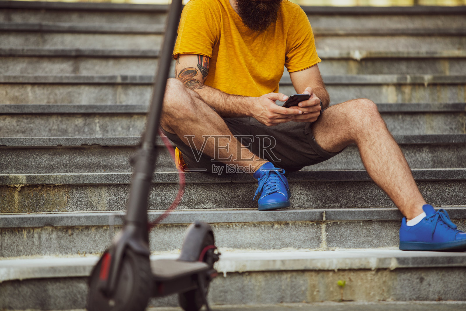 一个骑着电动车在电话上打字的潮人照片摄影图片