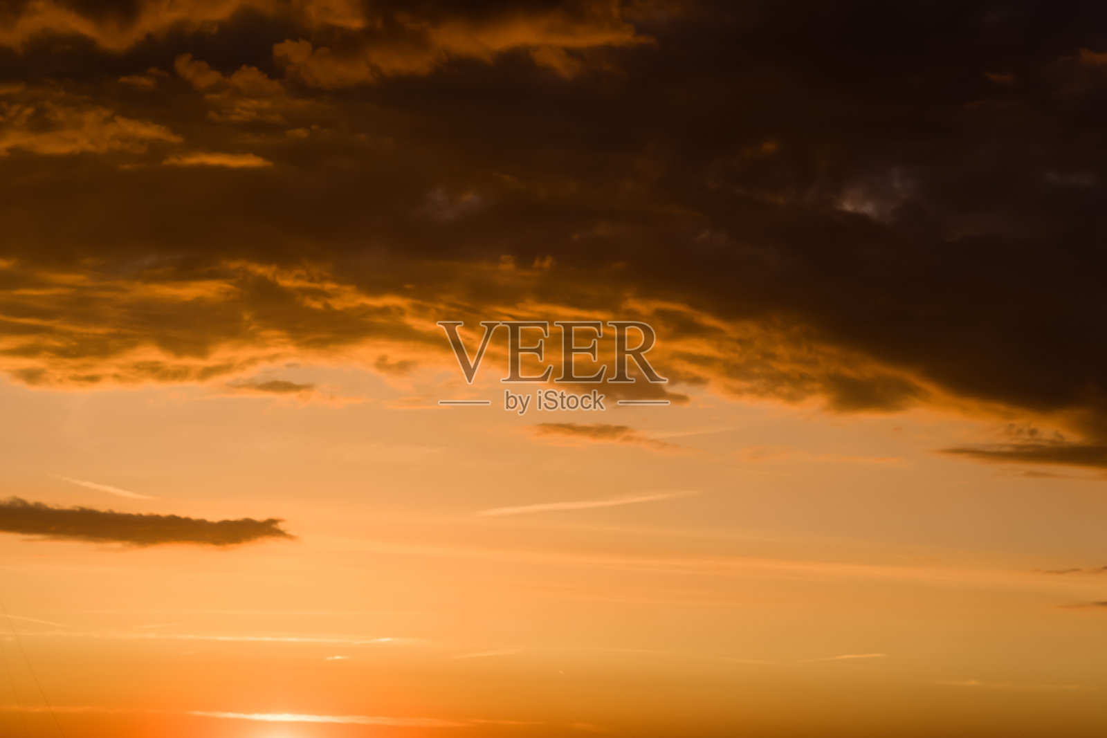 暴风雨戏剧性的天空背景与黄色、红色和橙色的云。日落地平线。海滩上的风暴照片摄影图片