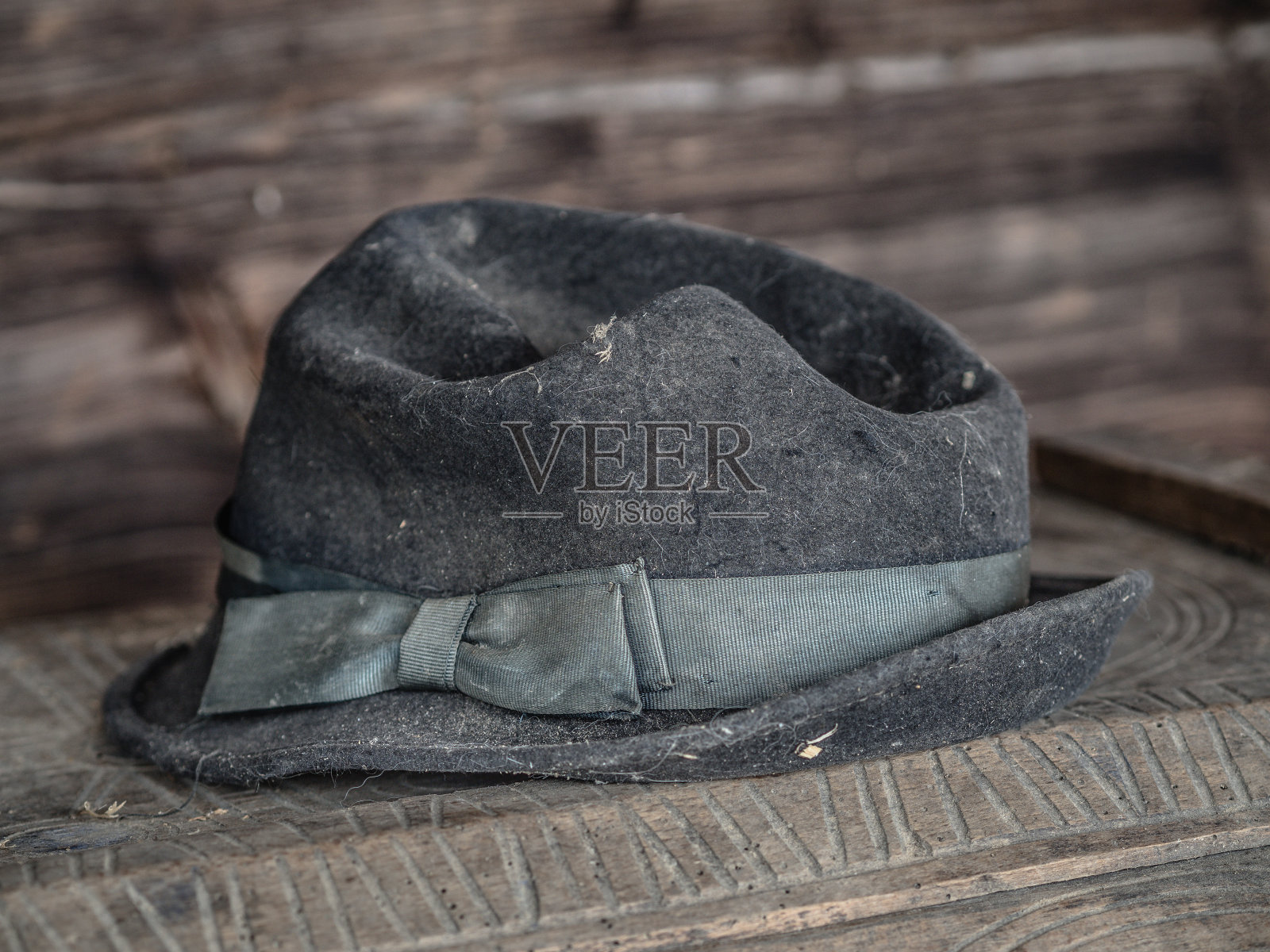 漂亮的黑色复古帽子与棕色的木制背景下的缎带躺在一个旧木箱上照片摄影图片