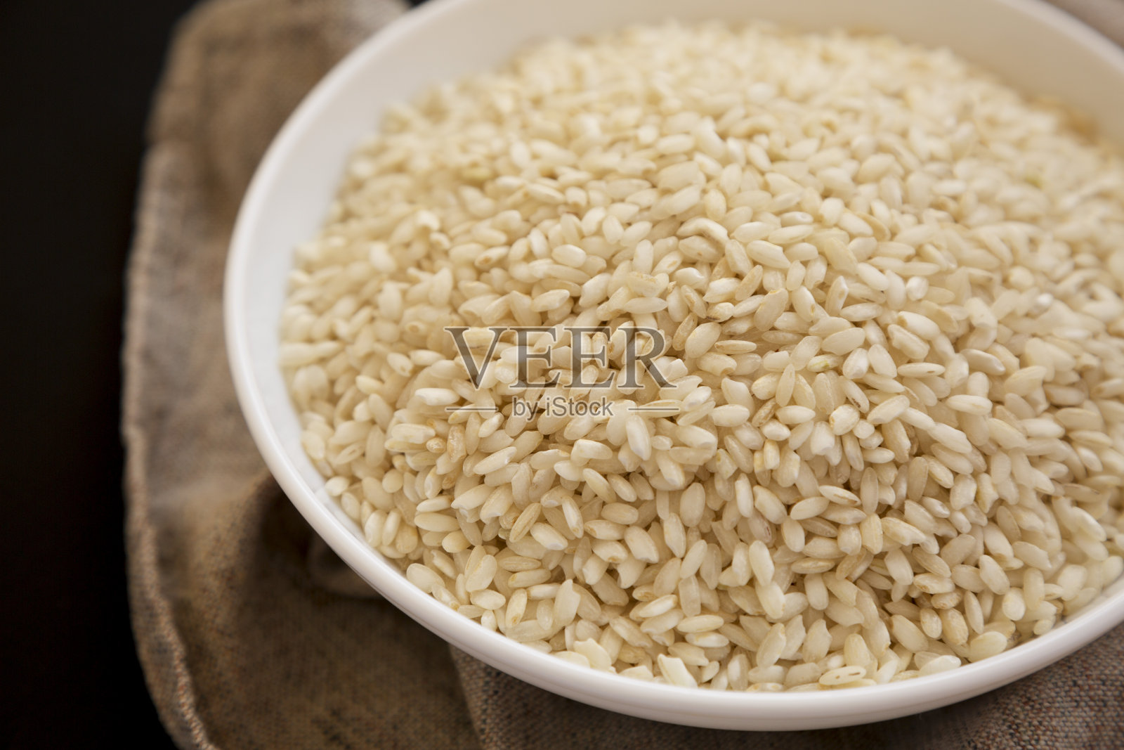 有机阿博里奥大米在白色的碗里,低角度观看。特写镜头。照片摄影图片