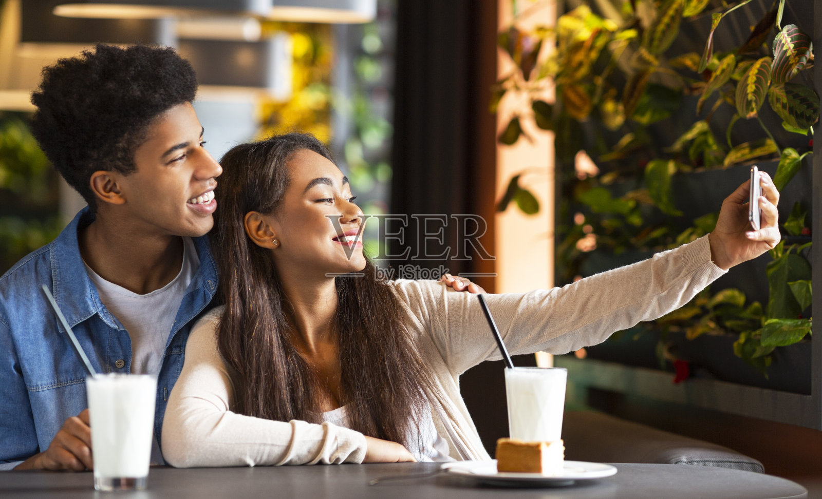 快乐的混血青年情侣在咖啡馆自拍照片摄影图片