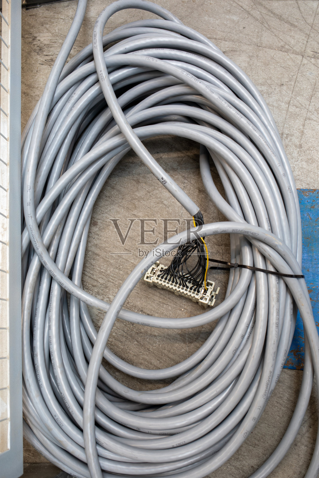 地板上放着一卷灰色的电缆,末端有一个开关照片摄影图片