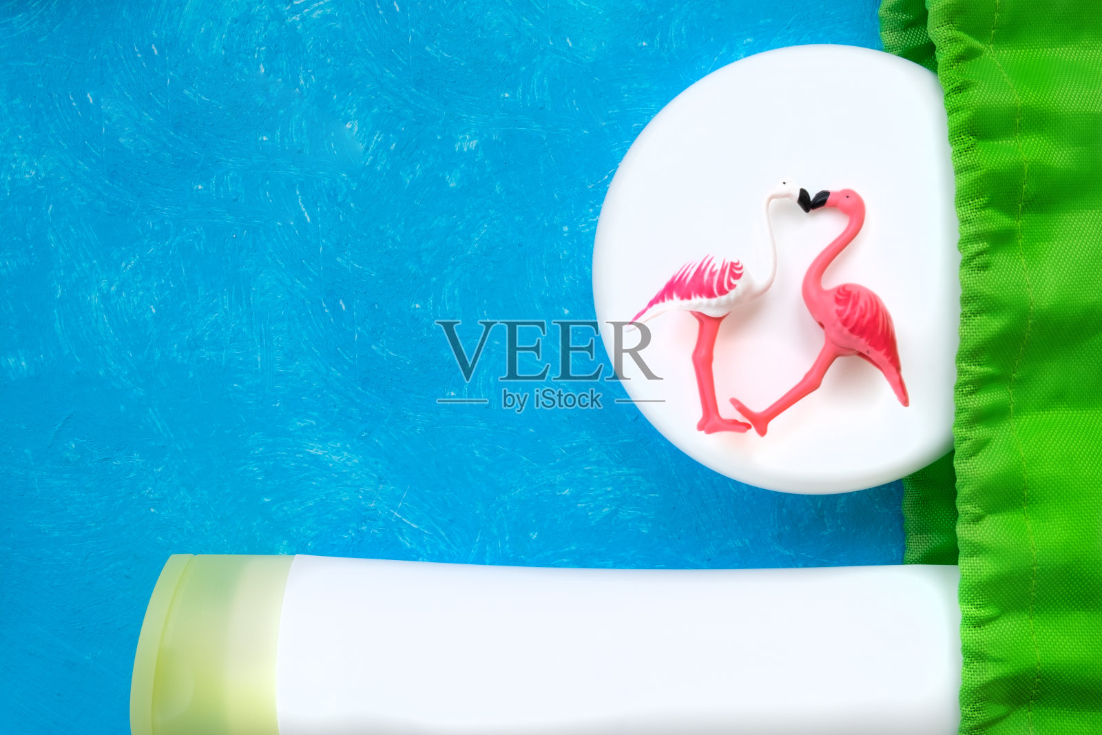 白色画了两只火烈鸟,白色奶油在明亮的蓝色背景。照片摄影图片