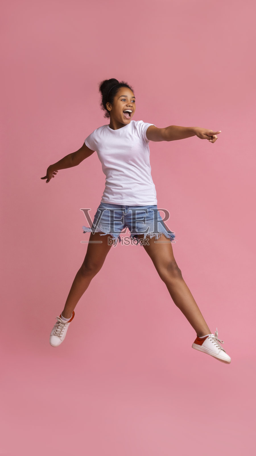 看那里。兴奋的非洲女孩跳了起来,指着一边照片摄影图片