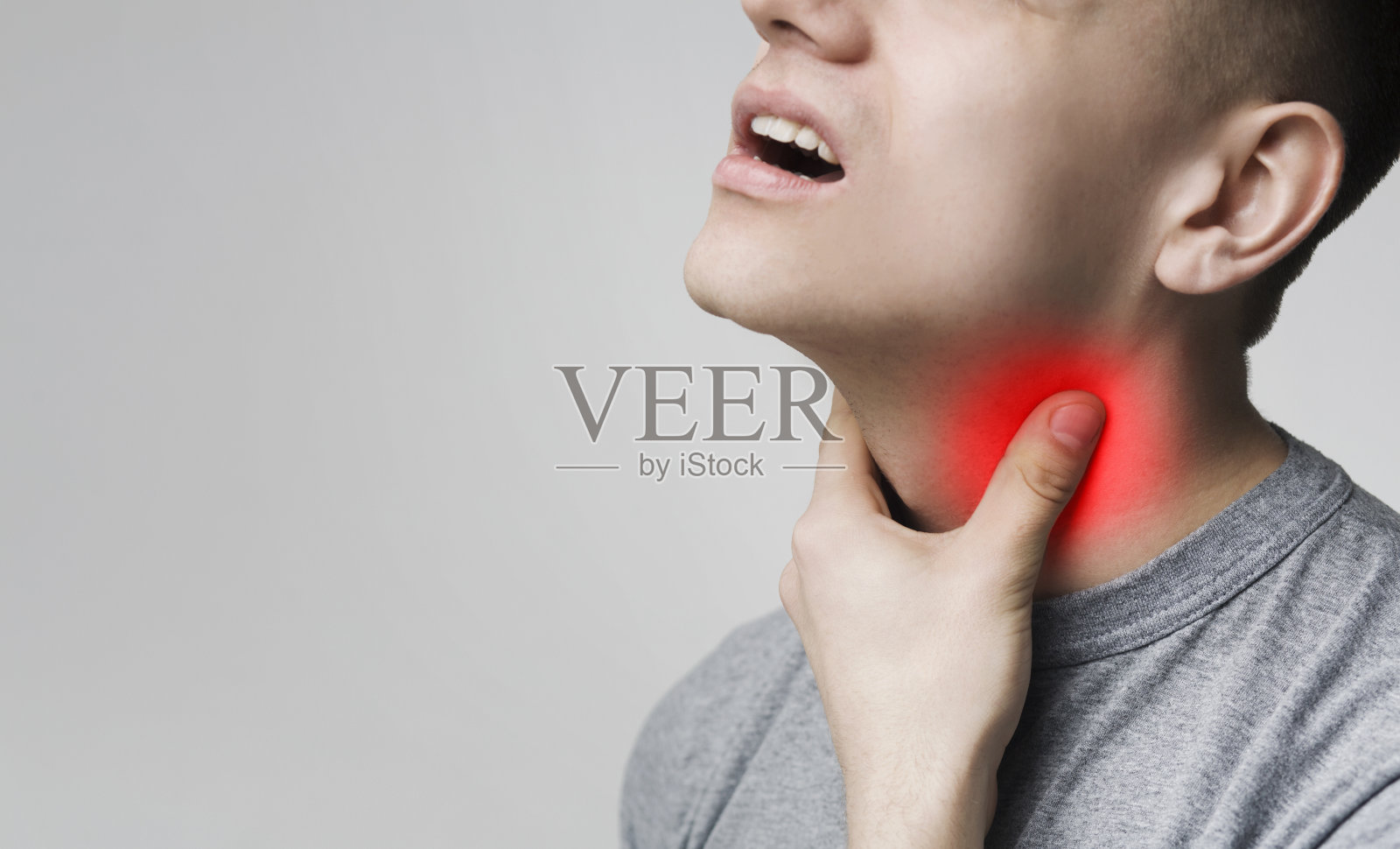 患有甲状腺疾病的男人,抚摸着自己的脖子照片摄影图片