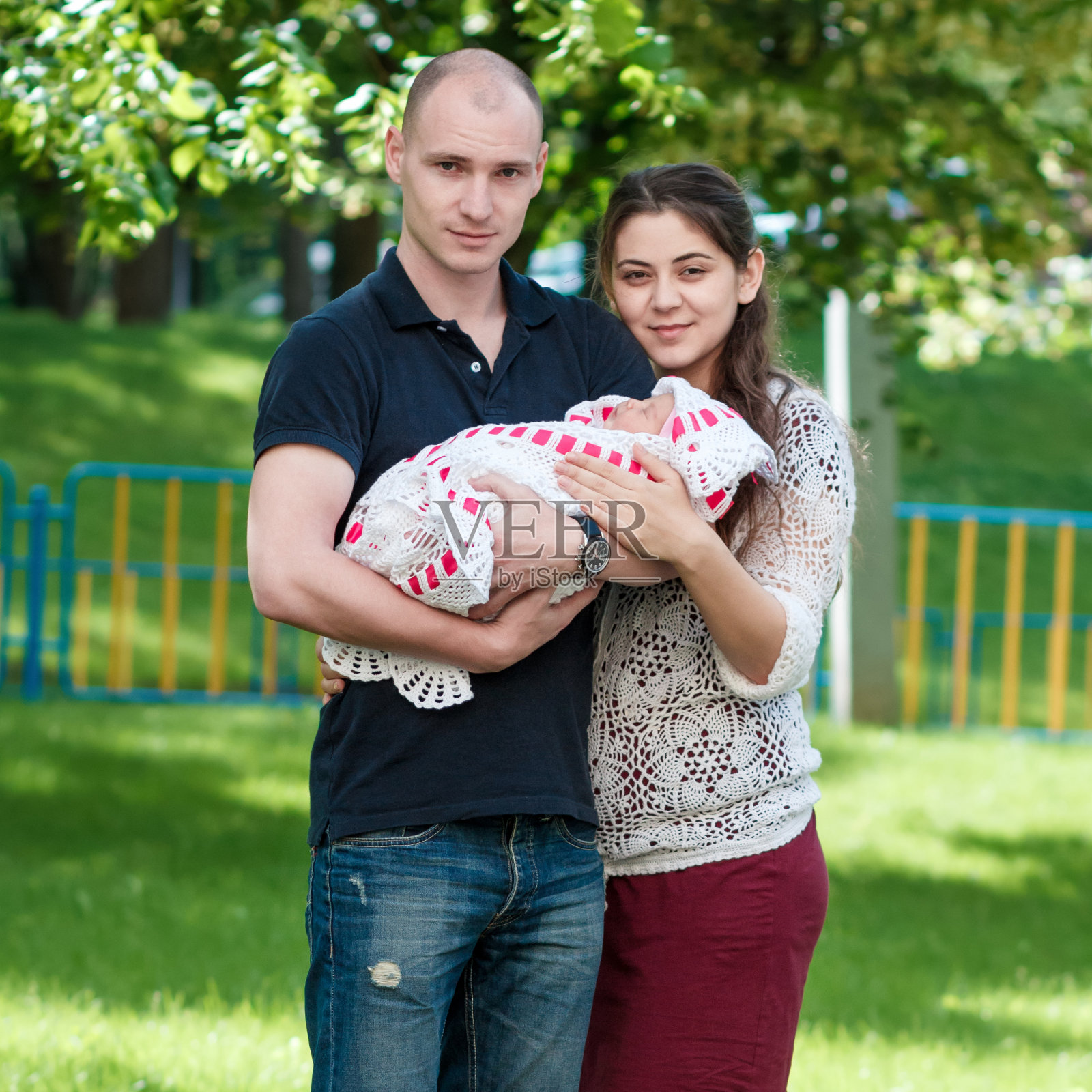 一对幸福的夫妇抱着他们刚出生的女儿。在户外照片摄影图片