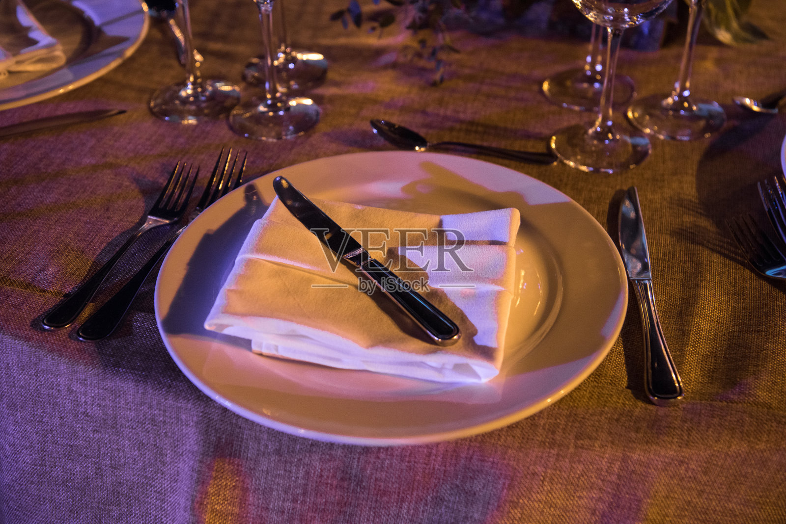 在宴会上用紫色的色调招待餐桌。晚上的照片。照片摄影图片