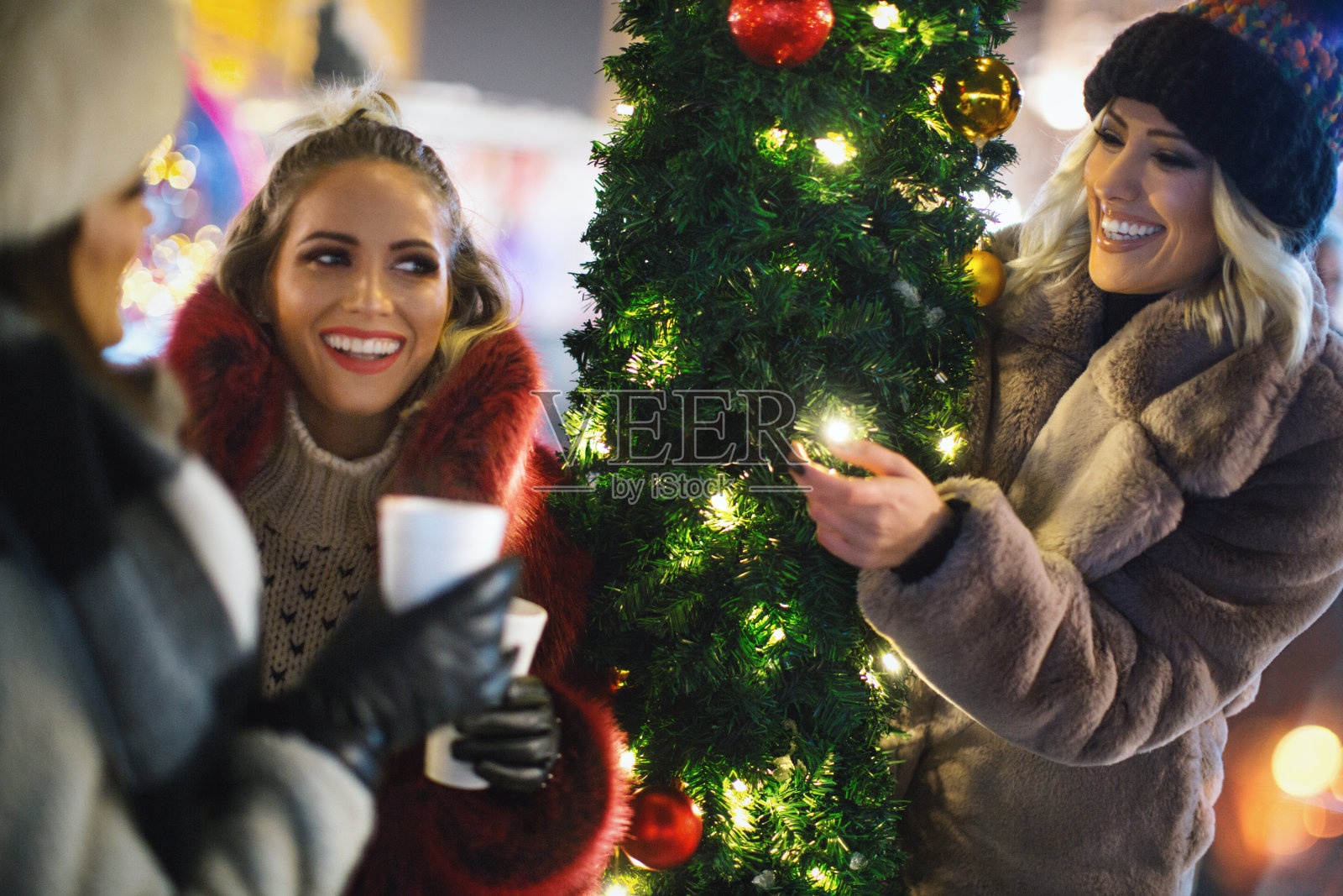 在圣诞市场上享用热红酒。照片摄影图片