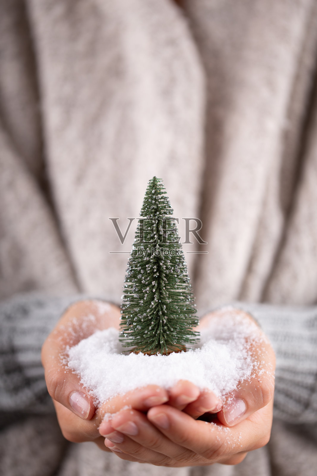圣诞装饰在女人手里。圣诞贺卡。女人的手握着圣诞节或新年装饰的礼物。照片摄影图片