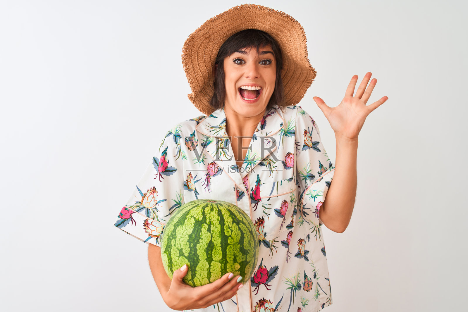 度假的女人戴着夏天的帽子拿着西瓜在孤立的白色背景非常高兴和兴奋,胜利者的表情庆祝胜利尖叫着大大的微笑和举起手照片摄影图片