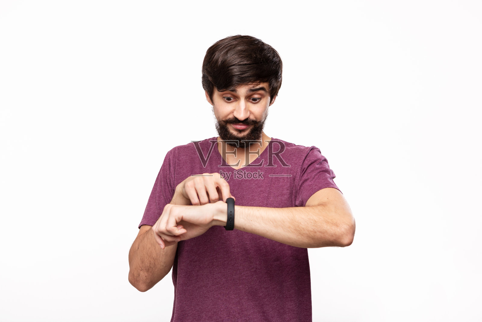 留着小胡子的黑发男子兴奋地用智能手表查看通知。在日常生活中使用现代科技。照片摄影图片
