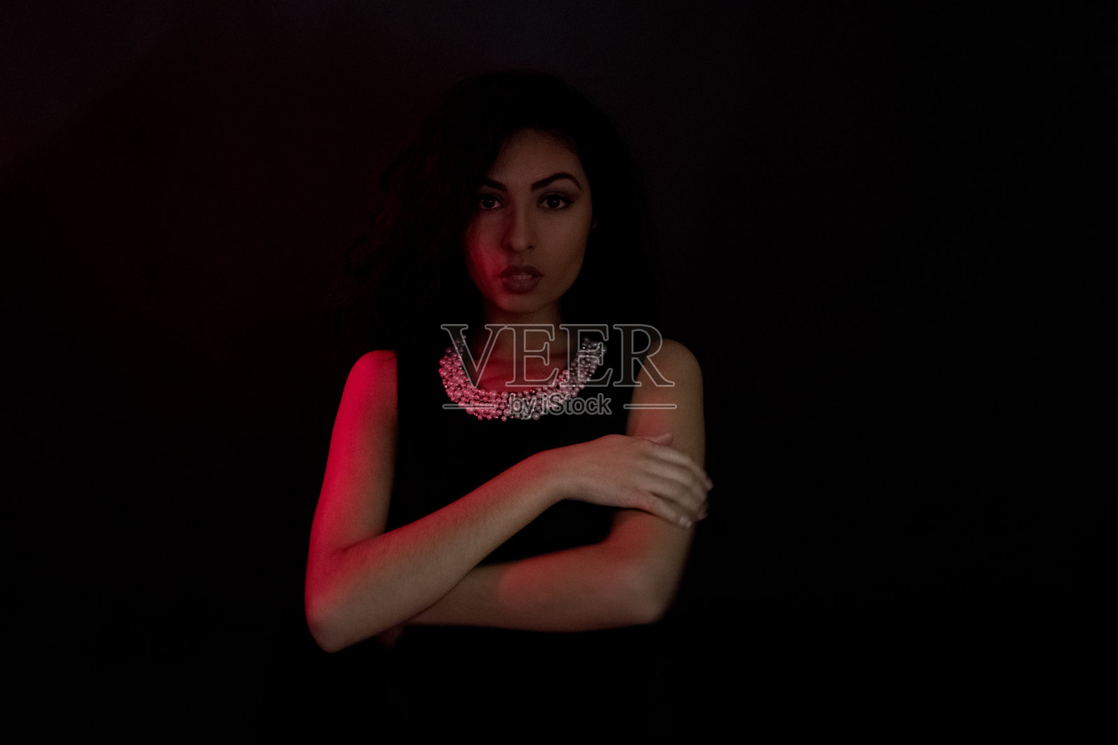 腰部以上/一个人/头像/ 18-19岁美丽的卷发/黑色头发拉丁美洲和西班牙裔的女性/年轻的女人十几岁的女孩在黑人背景/性感照片摄影图片