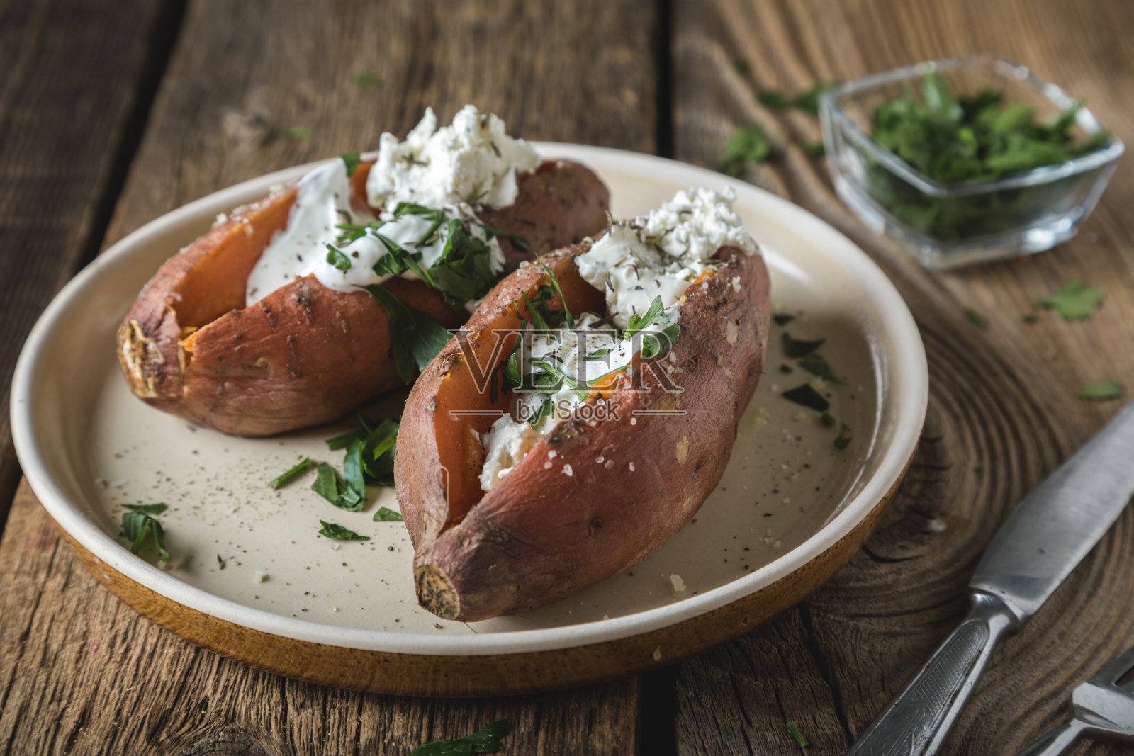 烤甘薯配奶油芝士,酸奶和新鲜香草照片摄影图片