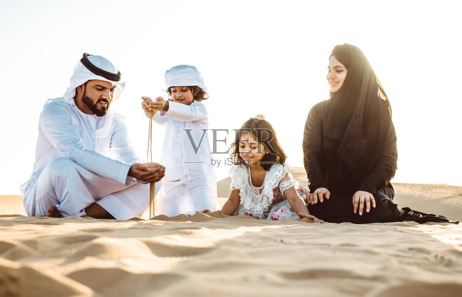 幸福的一家人在沙漠里野餐,度过美好的一天照片摄影图片