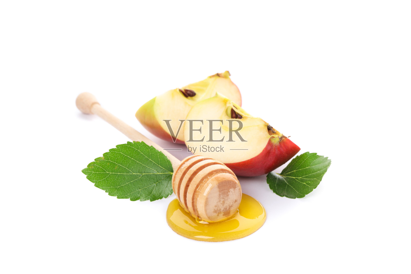 在白色的背景上,孤立的苹果片、叶子和带蜂蜜的勺子照片摄影图片
