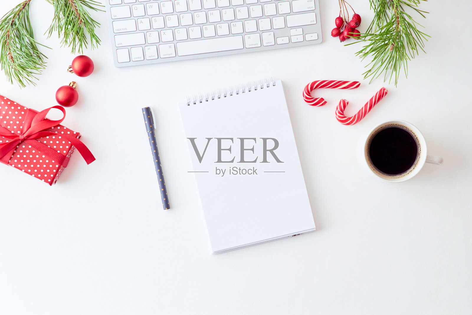 原型白色笔记本与松枝和键盘,圣诞装饰在白色的背景照片摄影图片