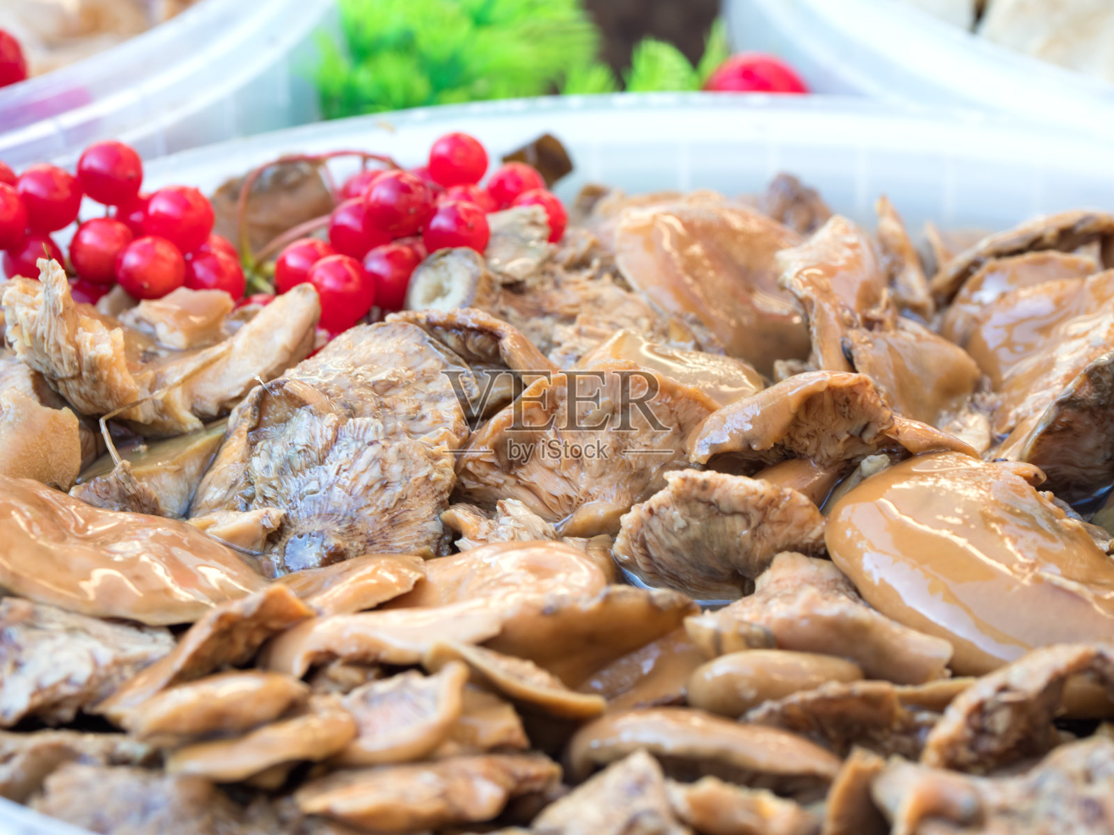 柜台上放着腌蘑菇。酸蘑菇配蔓越莓。照片摄影图片