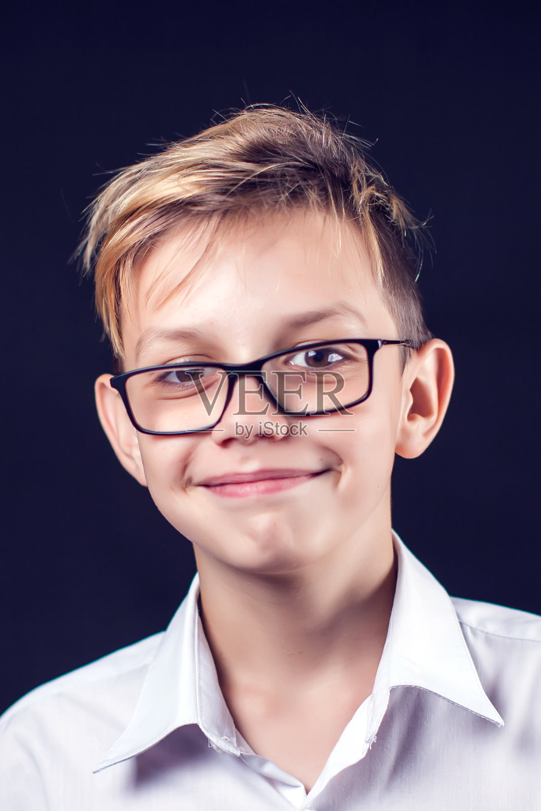 黑色背景上的一个微笑男孩的肖像照片摄影图片